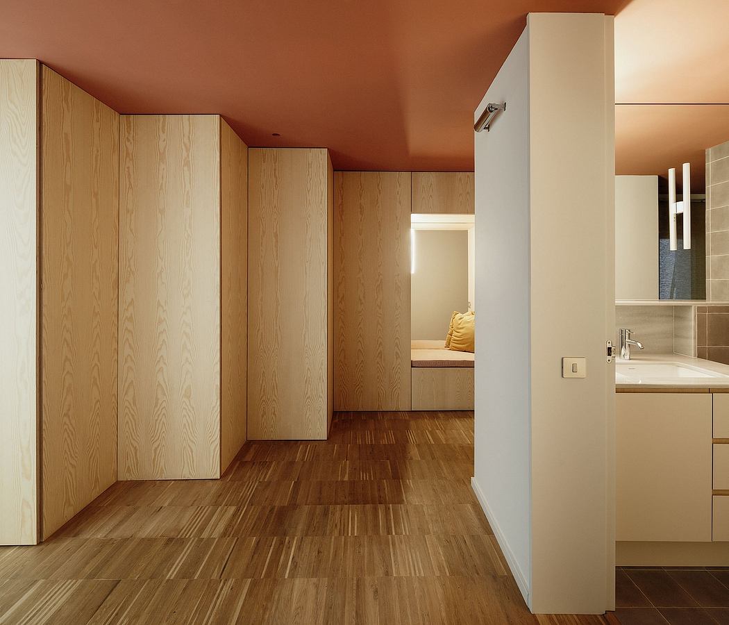 Warm-toned, wood-paneled room with built-in storage and minimalist furnishings.