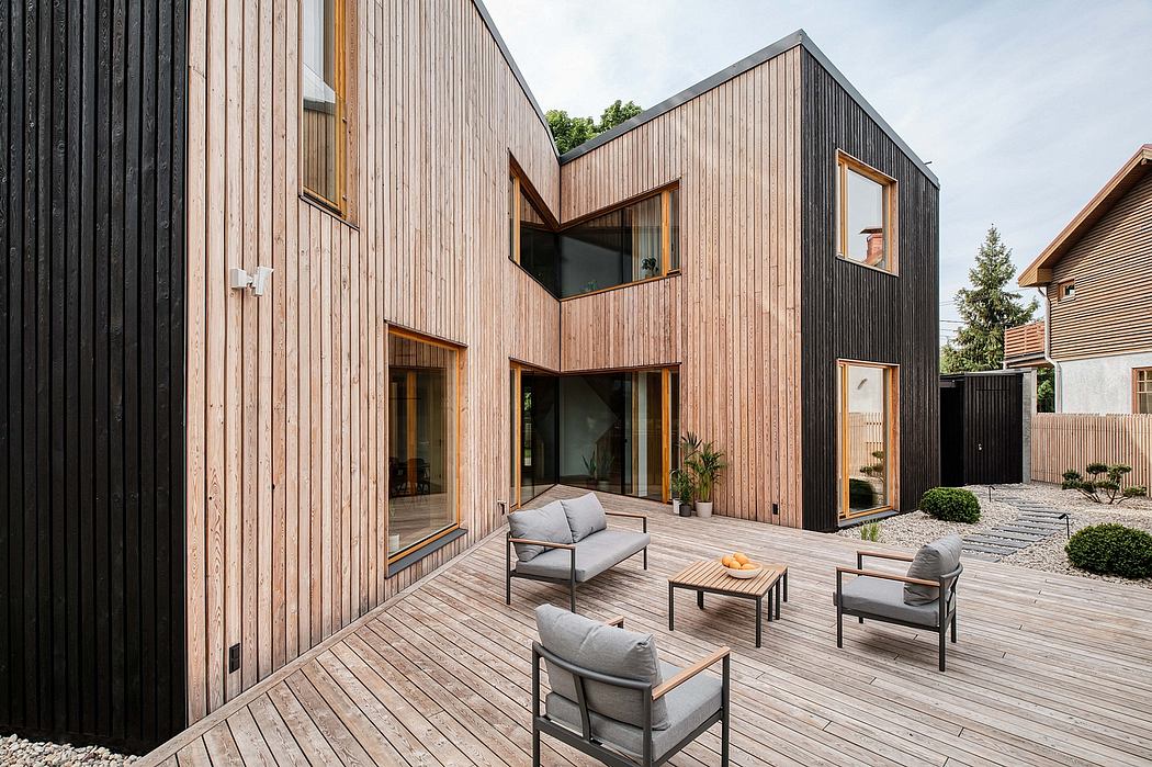 Striking modern wooden architecture with outdoor seating area and large windows.