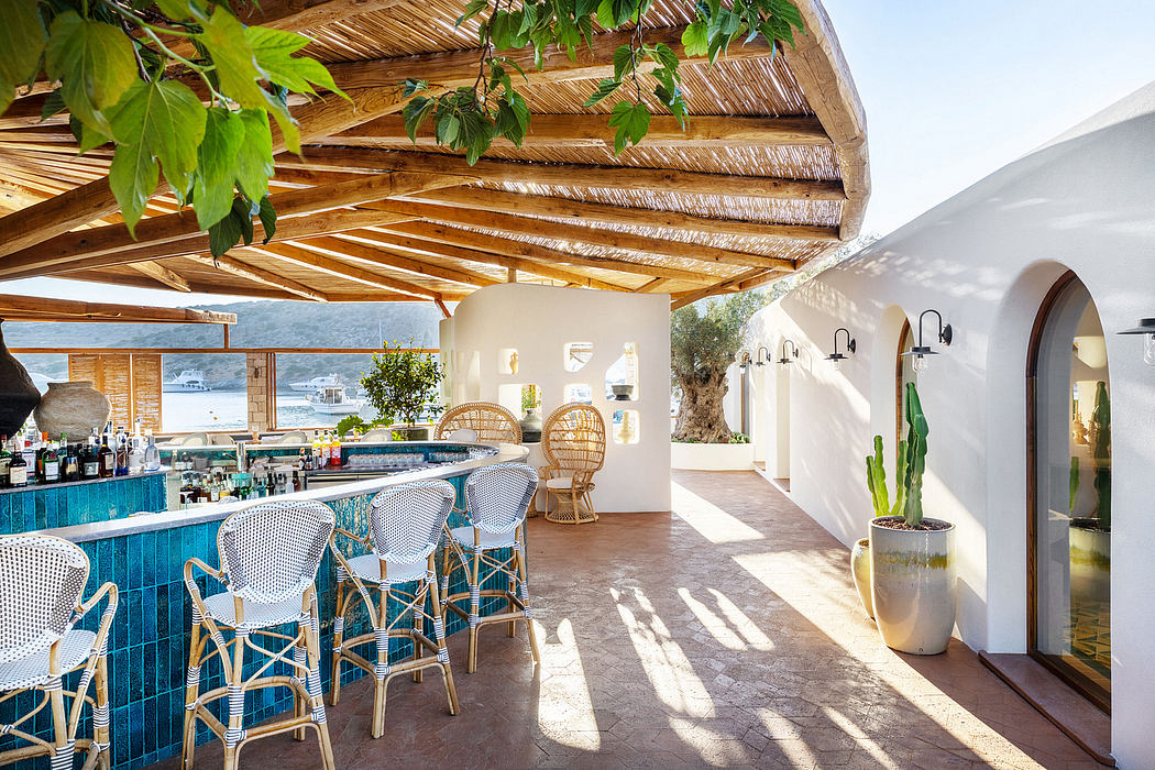 A tropical, open-air restaurant with a thatched roof, colorful tile bar, and wicker seating.