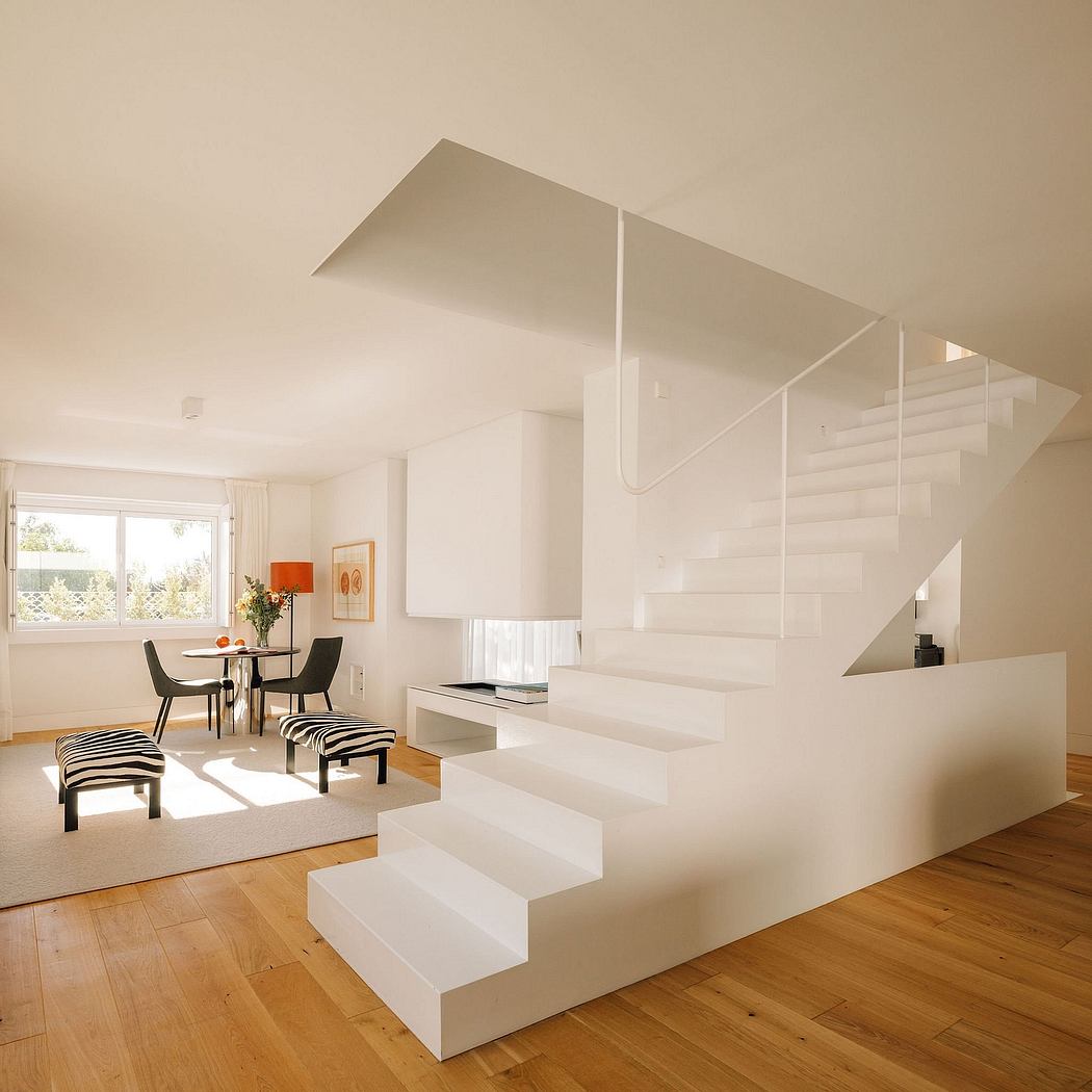 Minimalist white staircase leading to elevated dining area with modern furnishings.