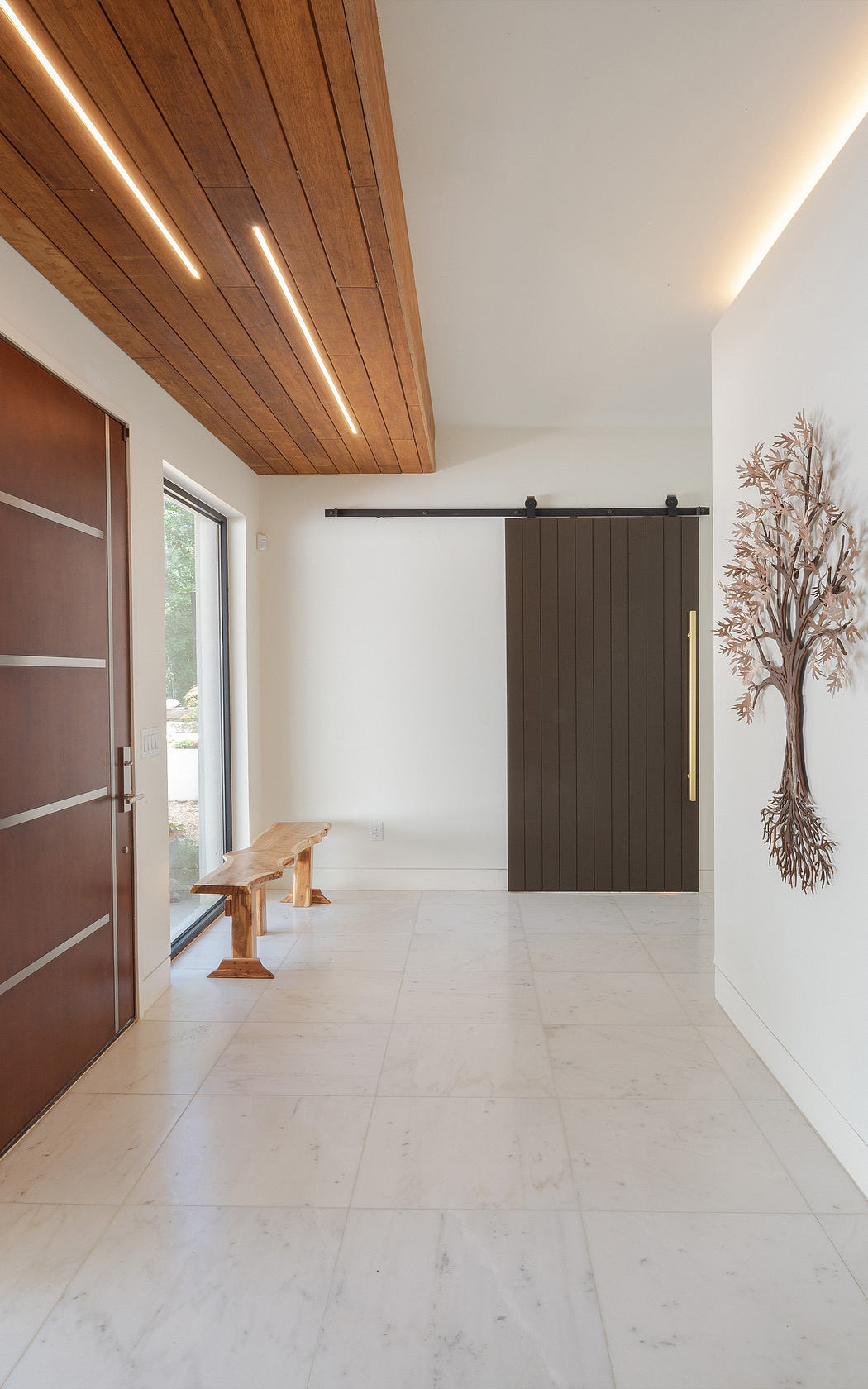 Spacious entryway with wooden ceiling, sliding barn door, and decorative wall art.
