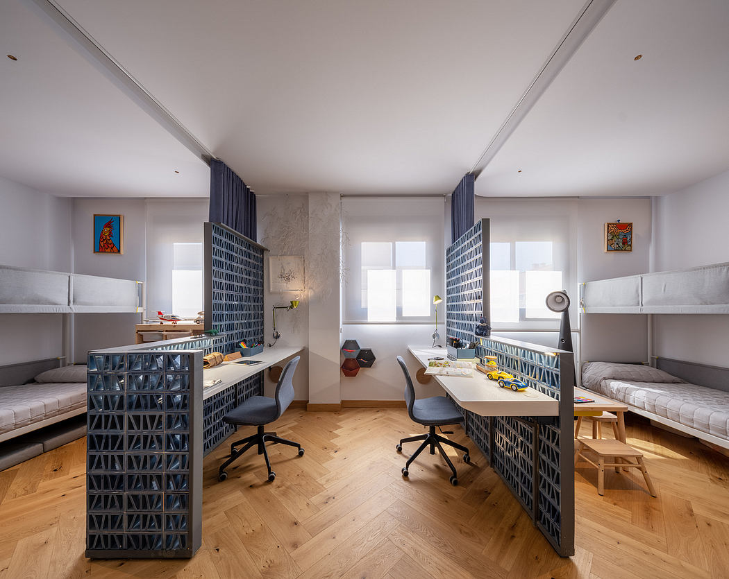A modern, minimalist dormitory space with built-in desks, shelving, and bunk beds.