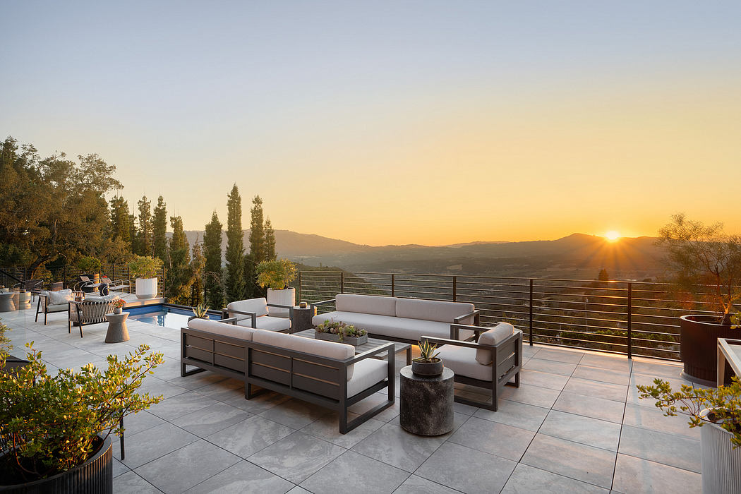 Expansive patio with modern furniture, sleek tile flooring, and captivating sunset view.