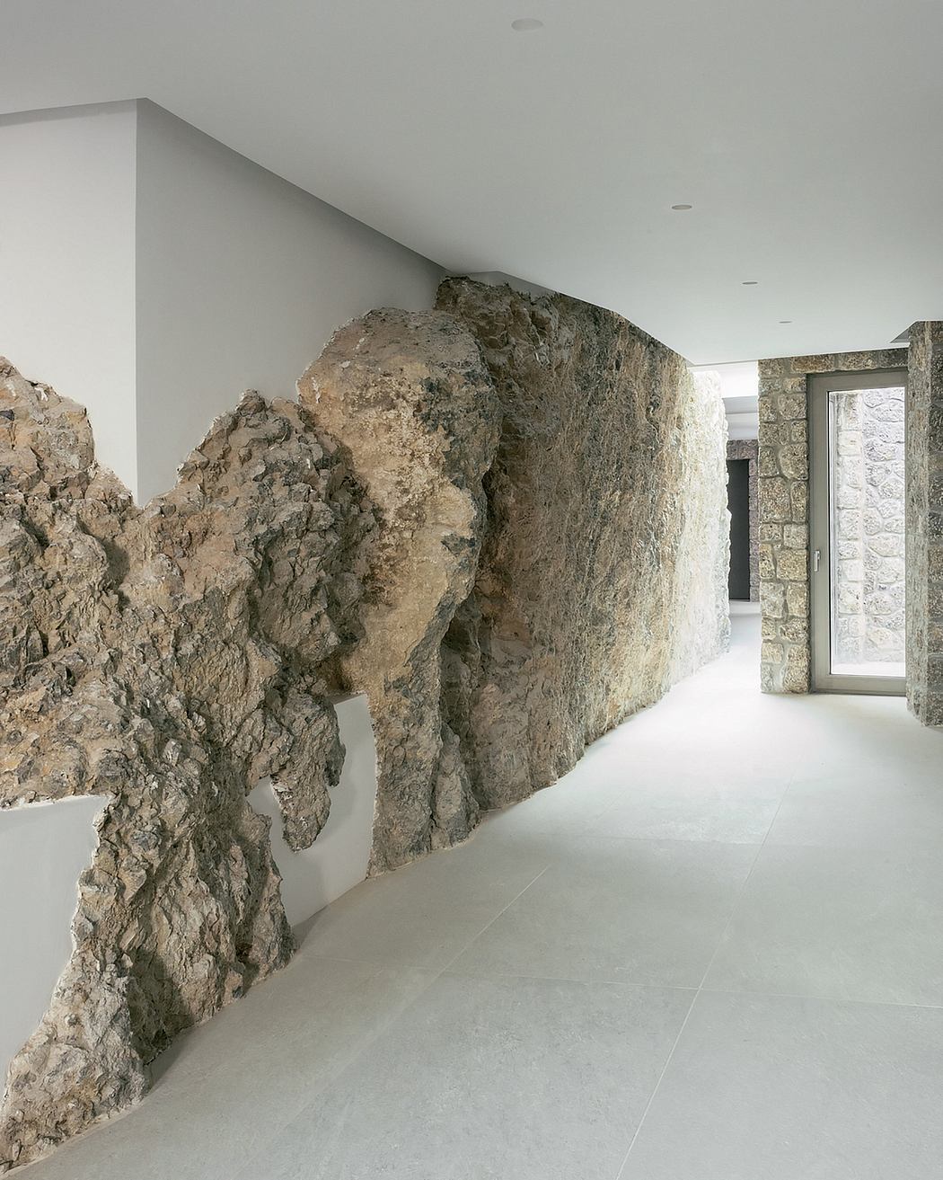 A modern interior design with dramatic rock formations integrated into the walls.
