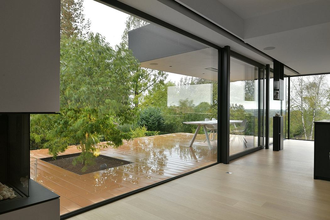 Contemporary home with expansive glass walls, indoor pond, and lush outdoor views.