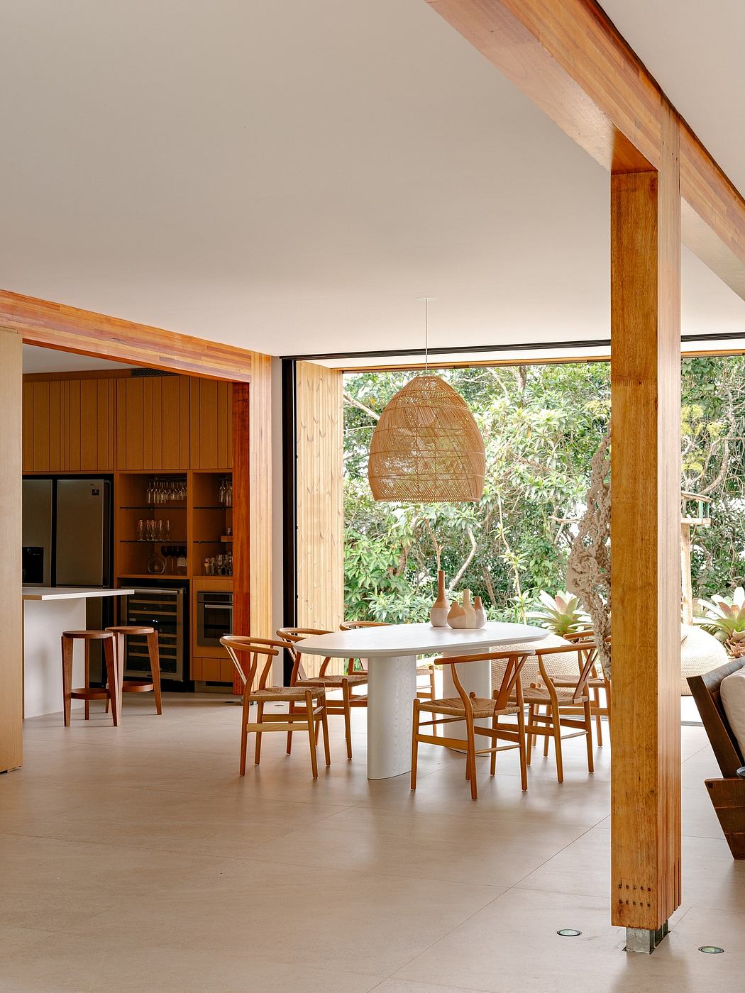 An open-concept dining area with warm wood accents and a woven pendant light.