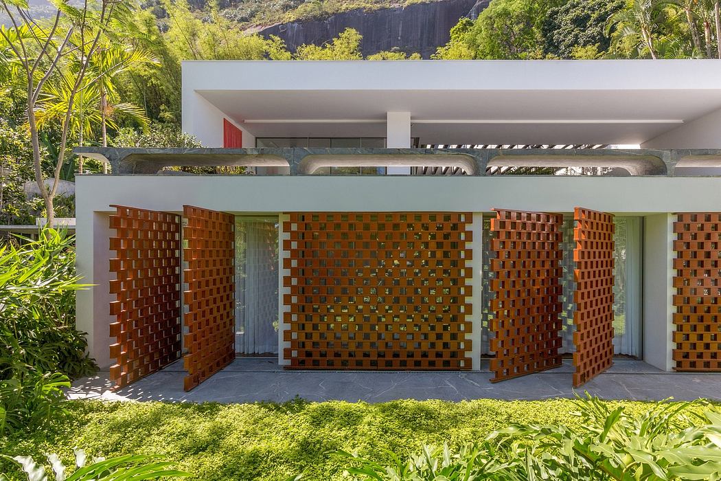 A modern architectural design featuring geometric brick patterns and lush vegetation.