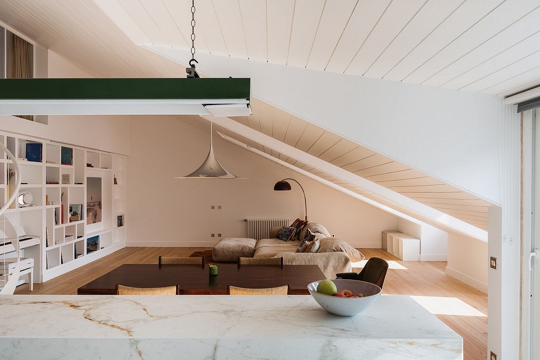 Cozy loft-style space with wooden beams, built-in shelving, and a marble-topped table.