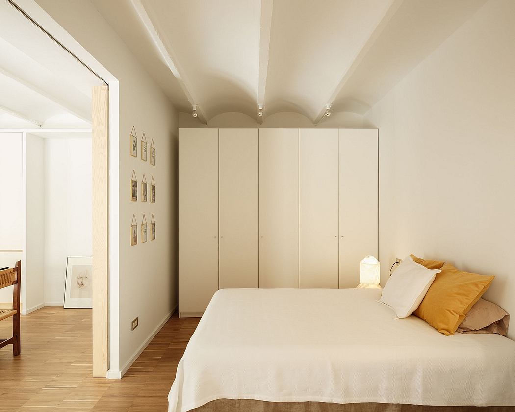 Minimal, well-lit bedroom with clean lines, neutral colors, and built-in cabinetry.