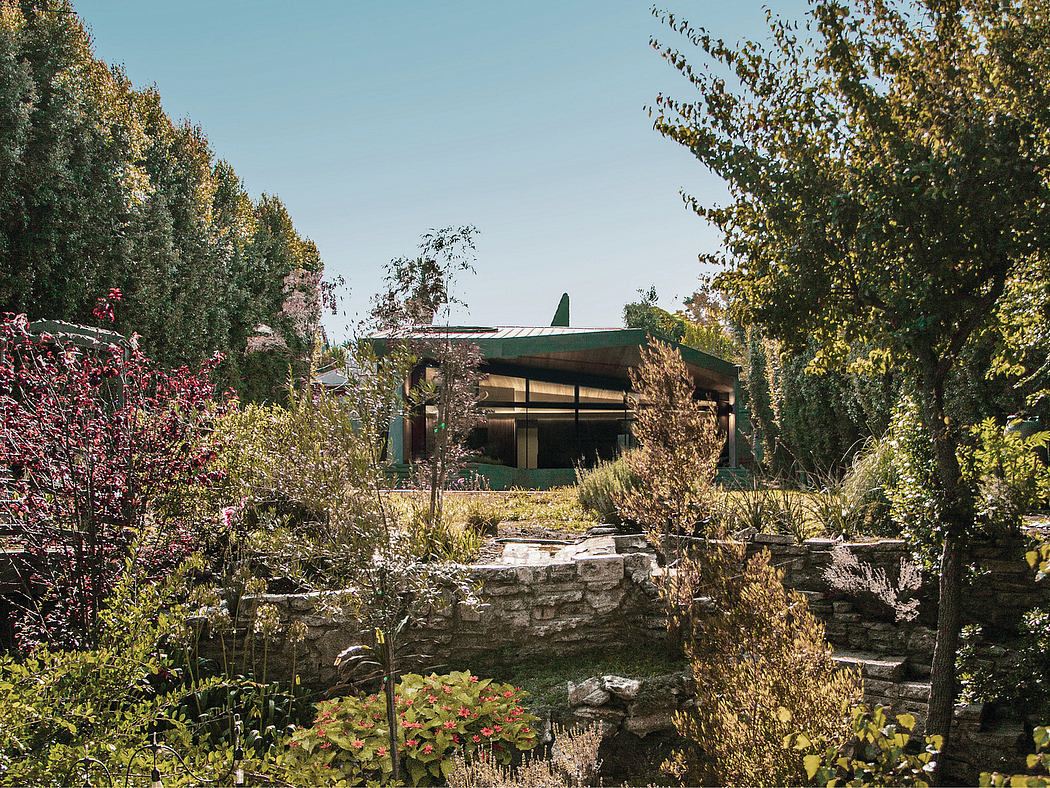 A unique modern structure nestled among lush, natural landscaping.