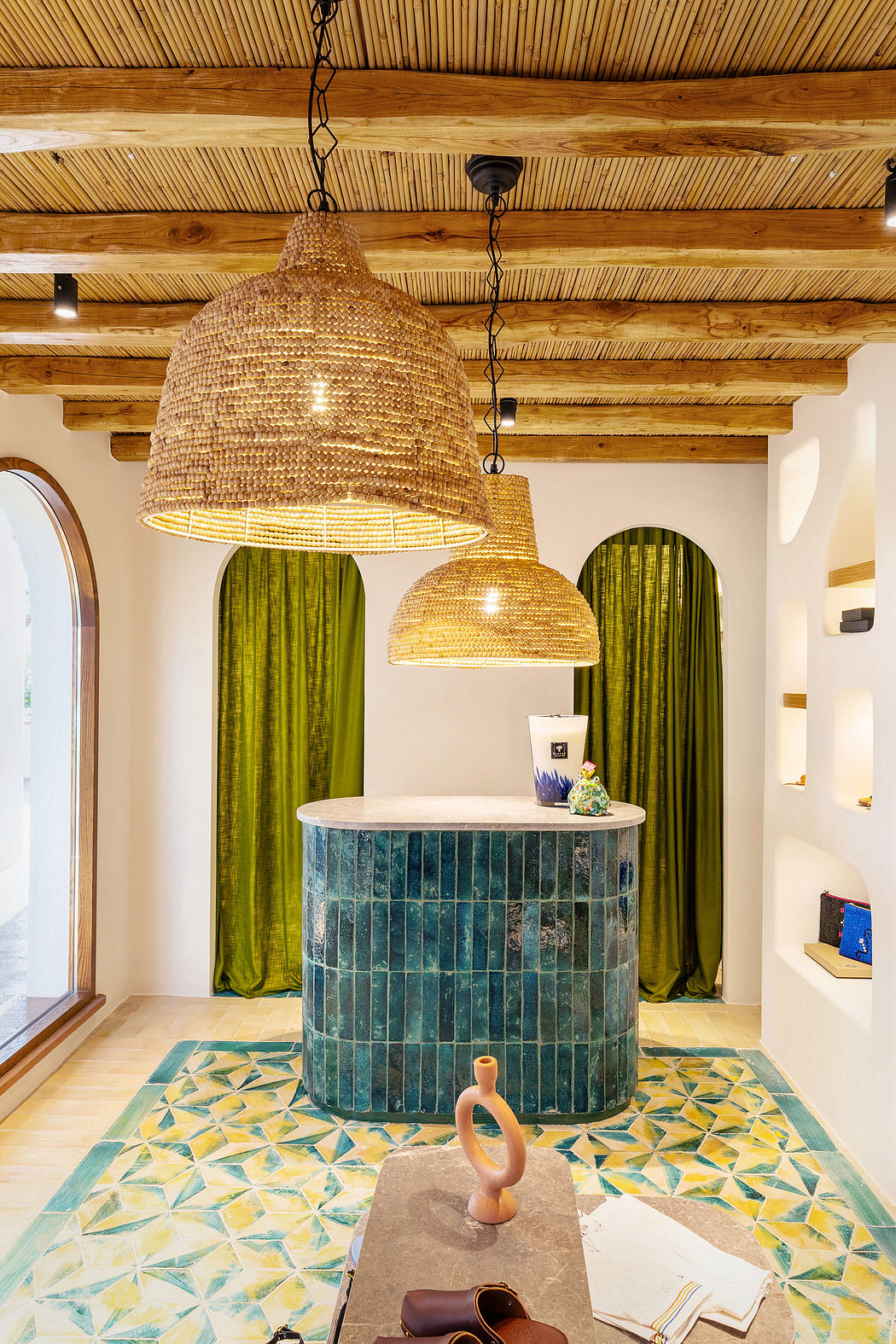 Rustic wooden ceiling beams, geometric mosaic tiles, and woven pendant lights create a warm, eclectic ambiance.