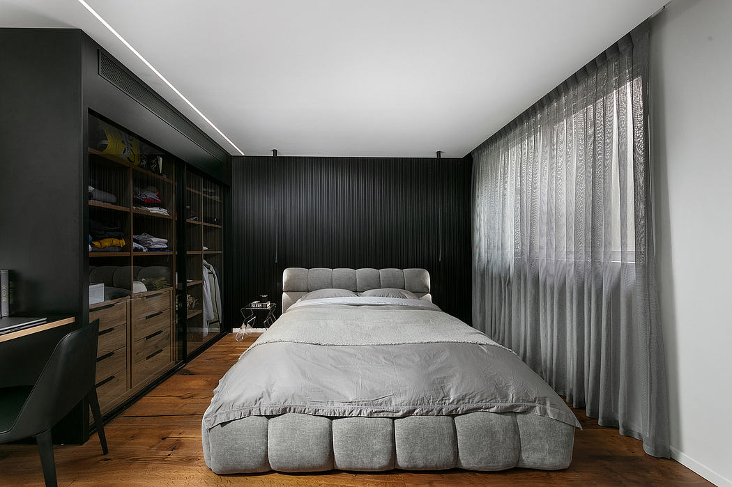 Spacious bedroom with dark walls, large bed, curtains, and a built-in storage unit.