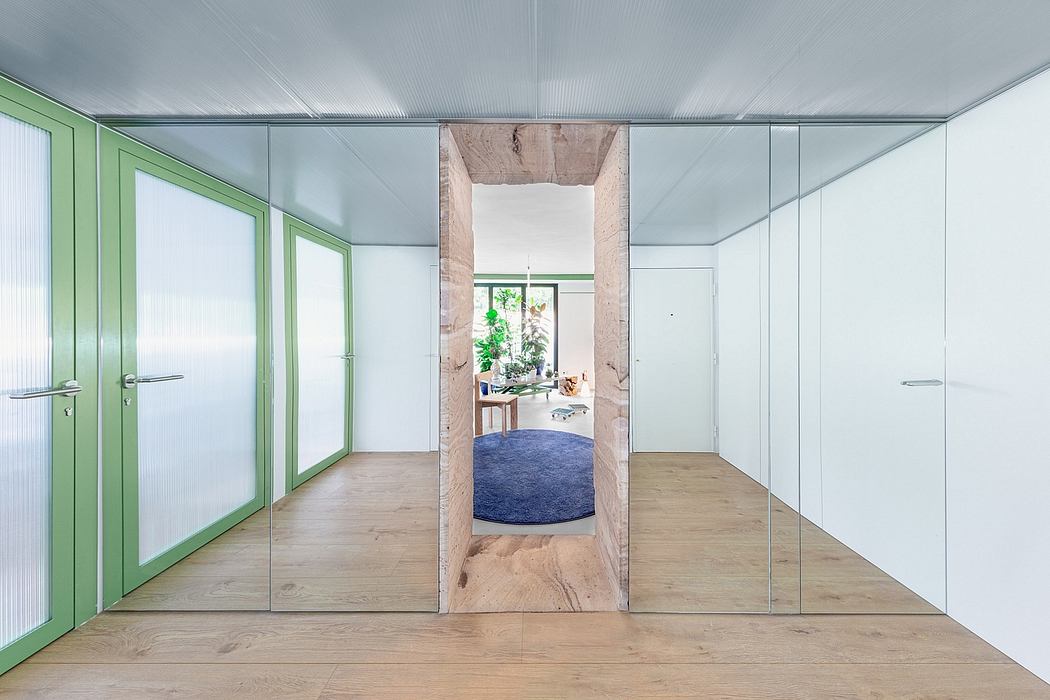 Minimalist interior with glass walls, wooden floor, and a circular rug visible through the doorway.