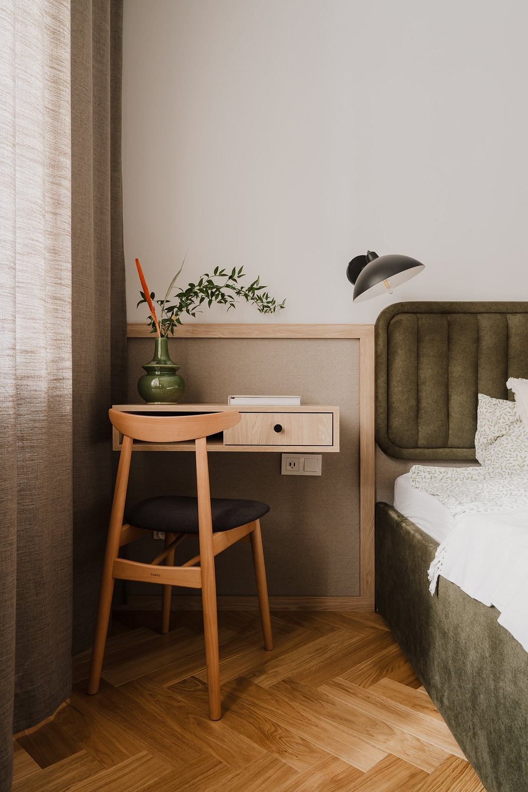 A cozy bedroom with warm wooden furniture, a potted plant, and a sleek black lamp.