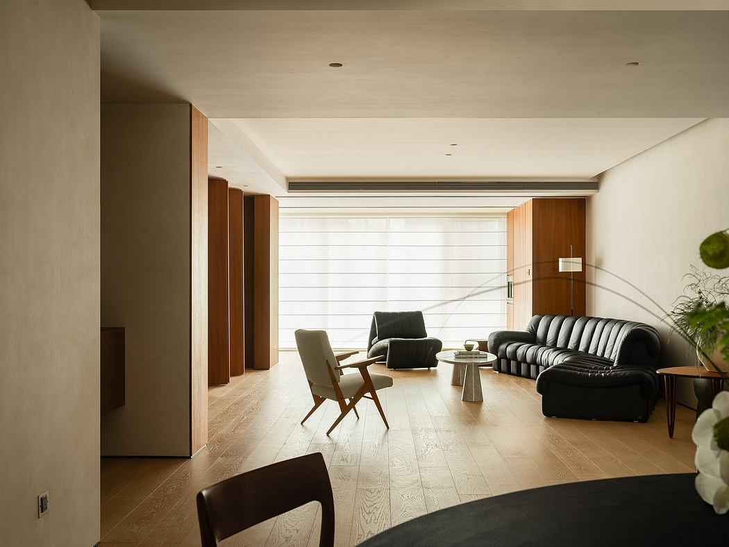 Spacious living room with wooden floors, ample seating, and clean, modern design.