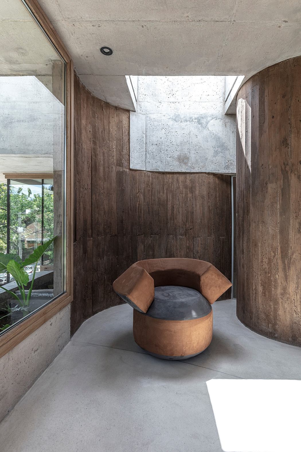 A modern, minimalist interior with concrete walls, wood accents, and a sculptural, organic chair.
