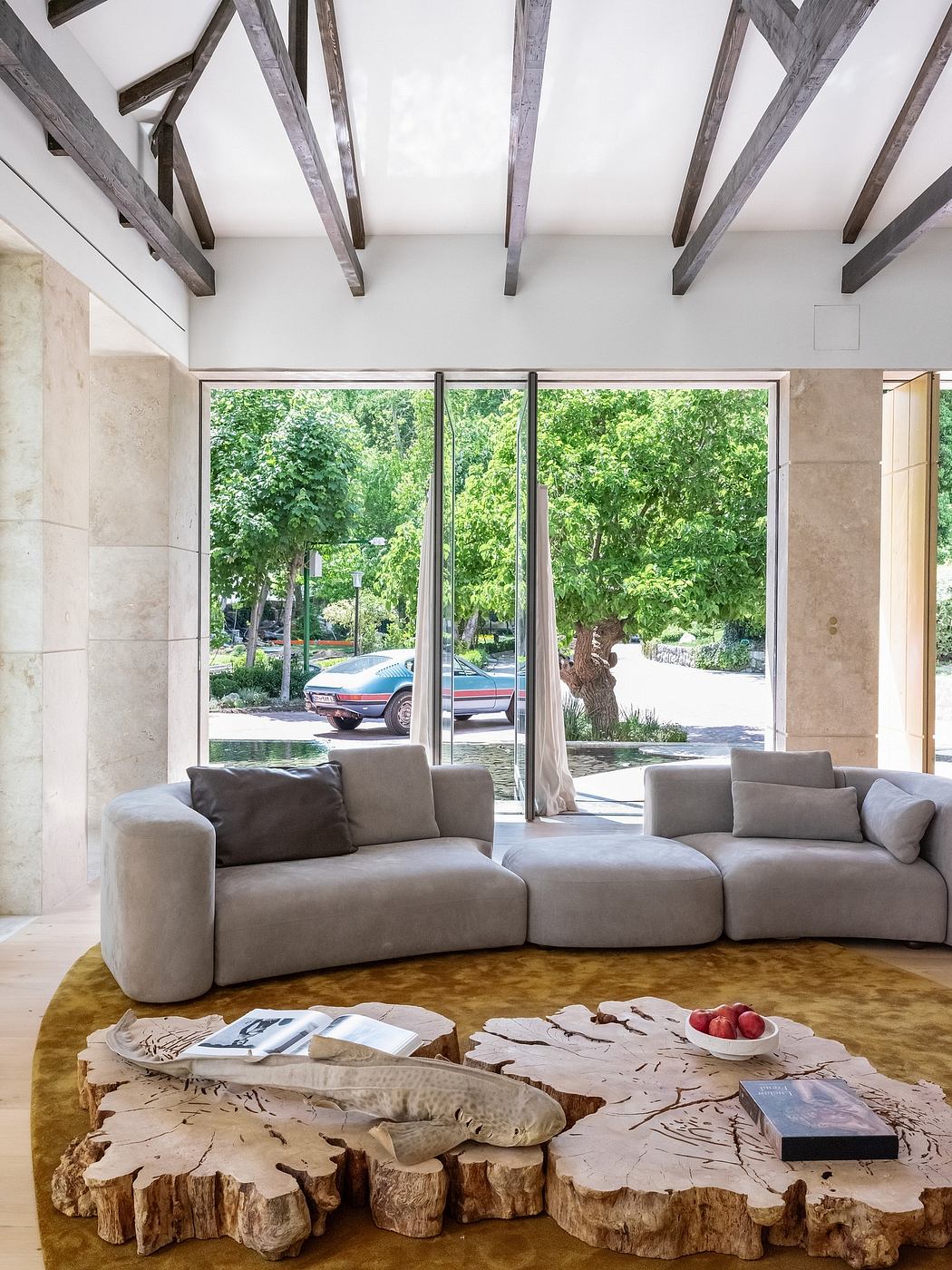 Cozy living area with rustic wood beams, expansive windows, and a stylish sectional sofa.