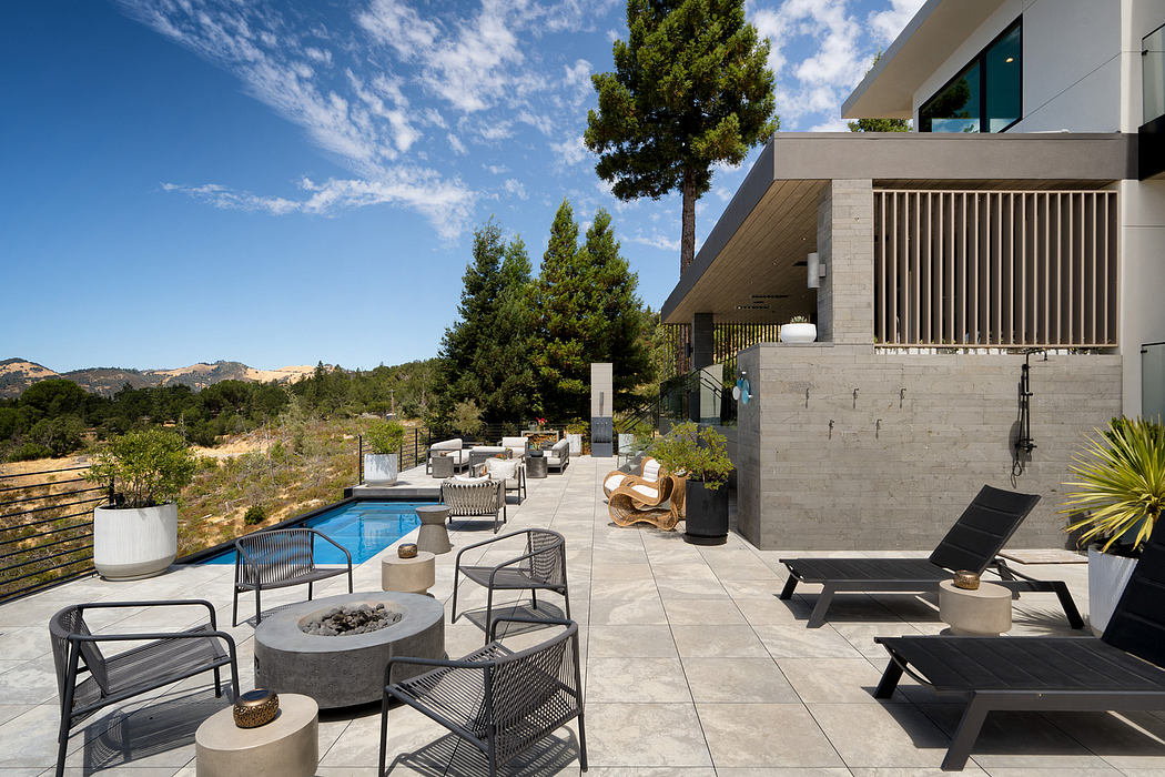 Spacious outdoor lounge with modern architecture, concrete accents, and lush greenery.