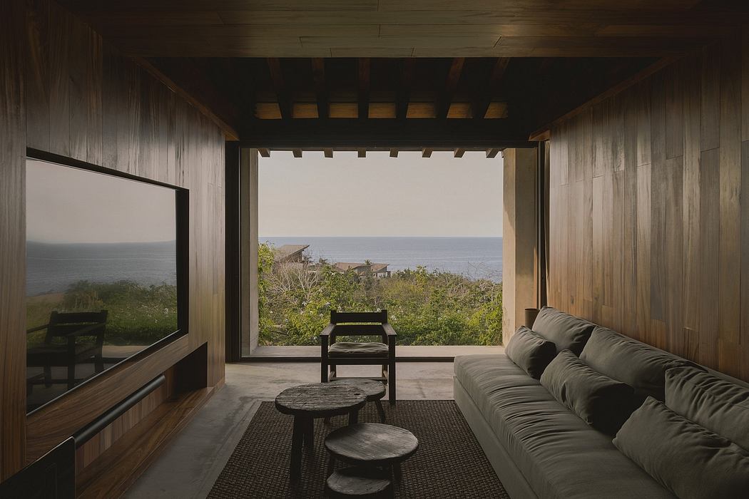 Spacious wooden room with scenic ocean view, minimalist furniture, and warm lighting.