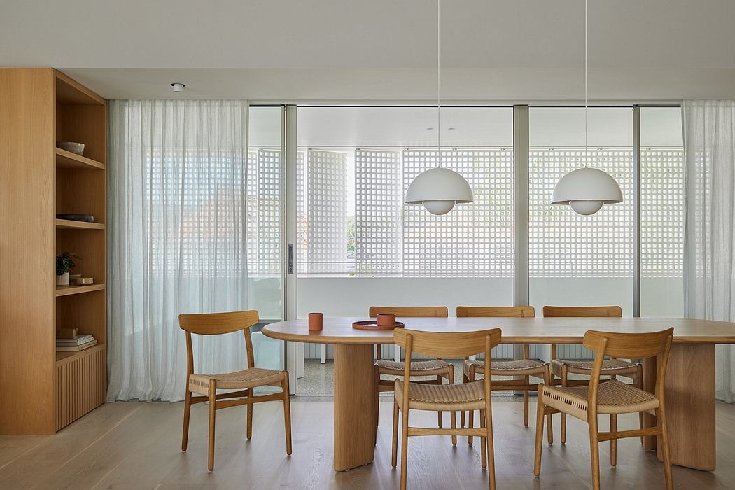 Spacious modern dining area with natural wood furnishings, textured curtains, and pendant lights.