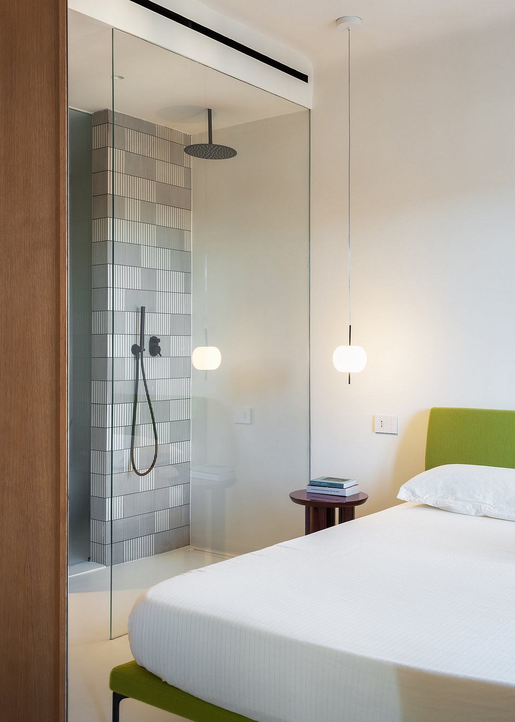 A modern bedroom design with a sleek glass shower and minimalist lighting fixtures.