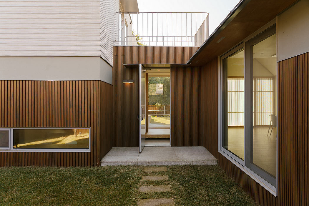 Sleek modern architecture featuring wooden slatted walls, glass windows, and a raised balcony.
