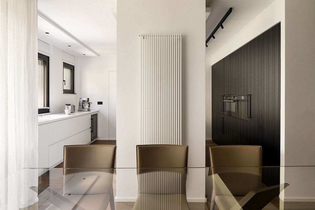 Modern minimalist kitchen with sleek white cabinets, black appliances, and streamlined radiator.