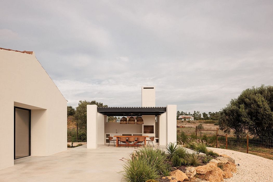 Modern outdoor kitchen and dining area with minimalist design and natural elements.