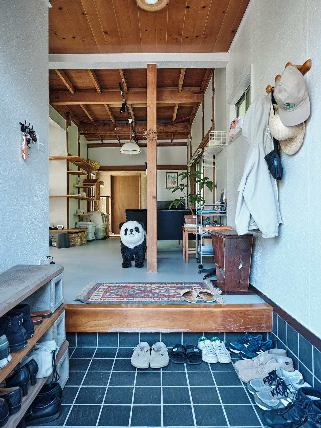 A cozy, rustic interior with wooden beams, storage, and a plush panda toy.