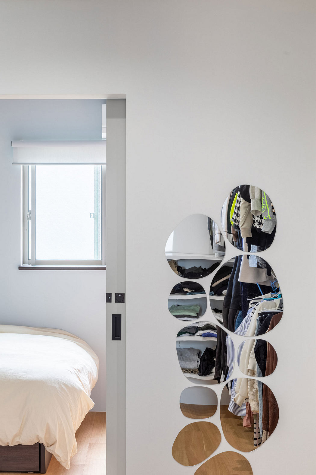 Modern bedroom with circular shelving displaying neatly organized clothing and decor.