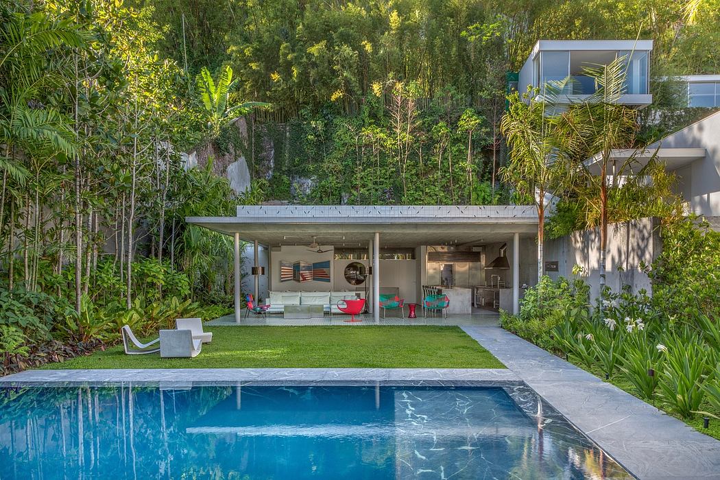 Lush tropical garden surrounds a modern, open-concept pavilion with pool and patio.
