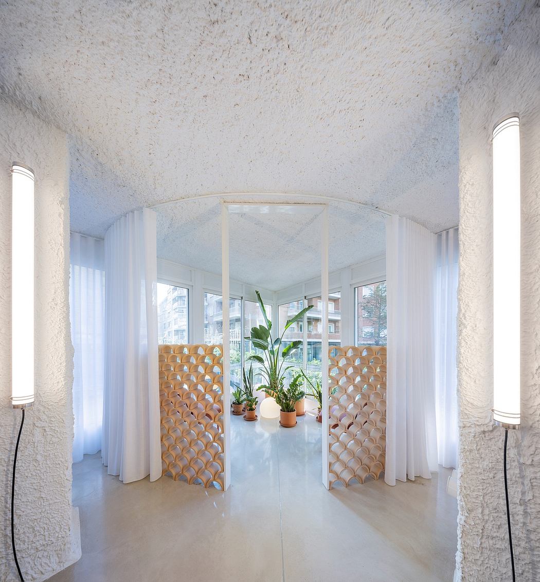 Minimalist, loft-style interior with arched doorways, light fixtures, and potted plants.