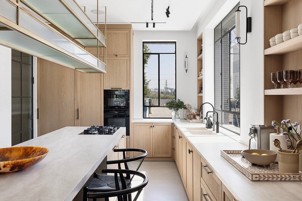 Spacious modern kitchen with oak cabinetry, sleek countertops, and large window.