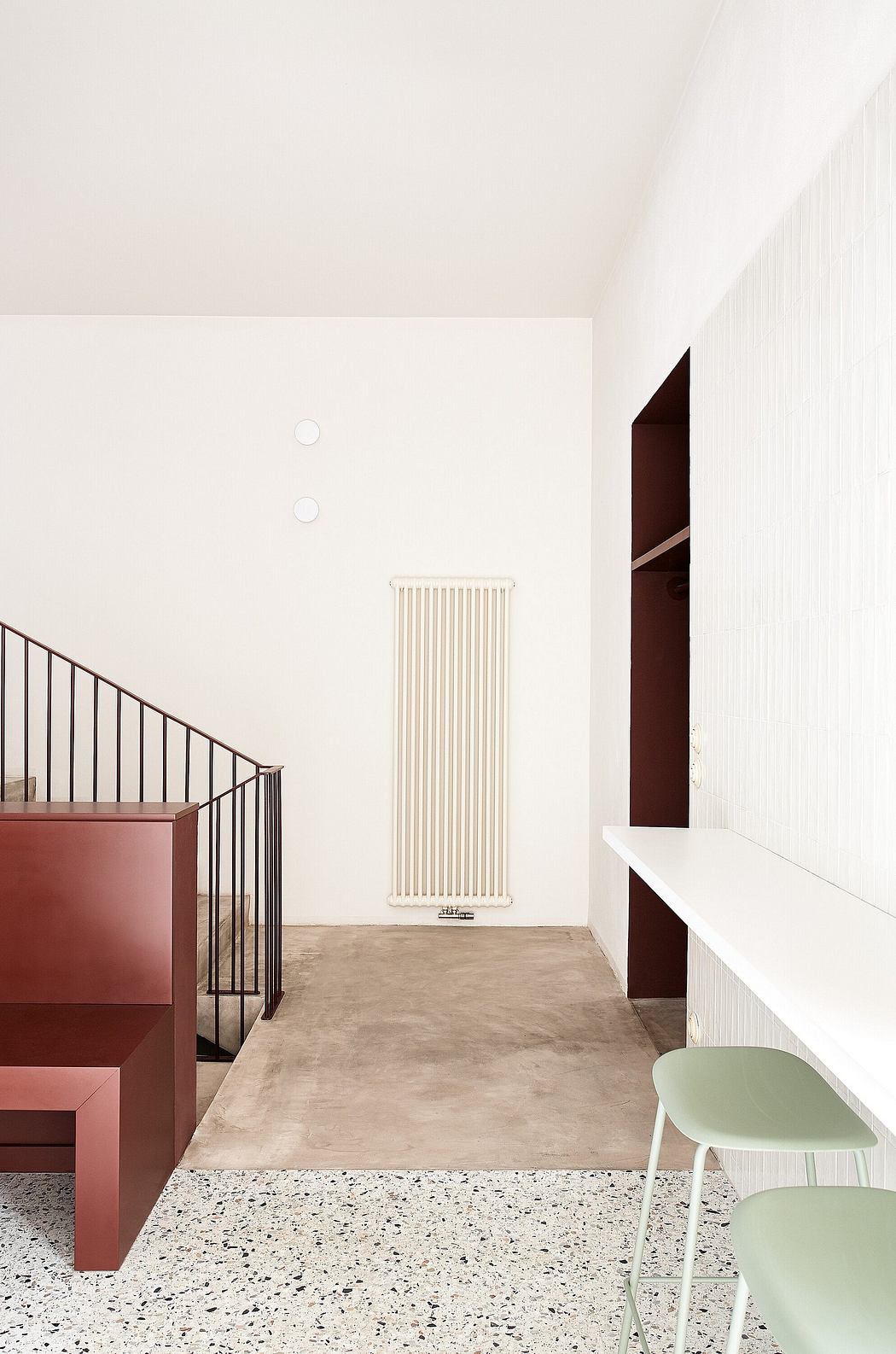 Minimalist interior with warm tones, concrete flooring, and a sleek radiator.