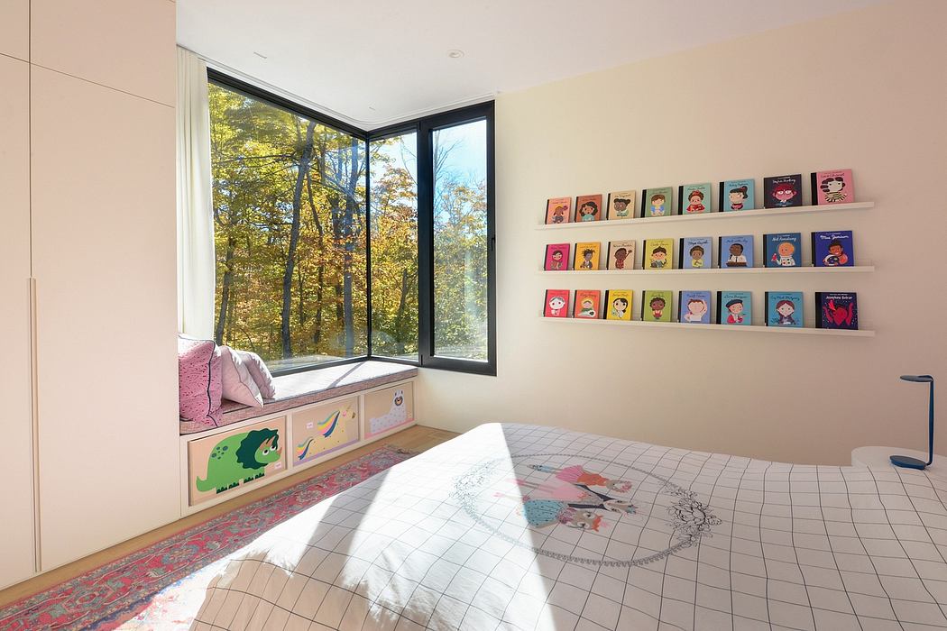 A cozy, modern children's bedroom with large windows overlooking an autumn landscape.