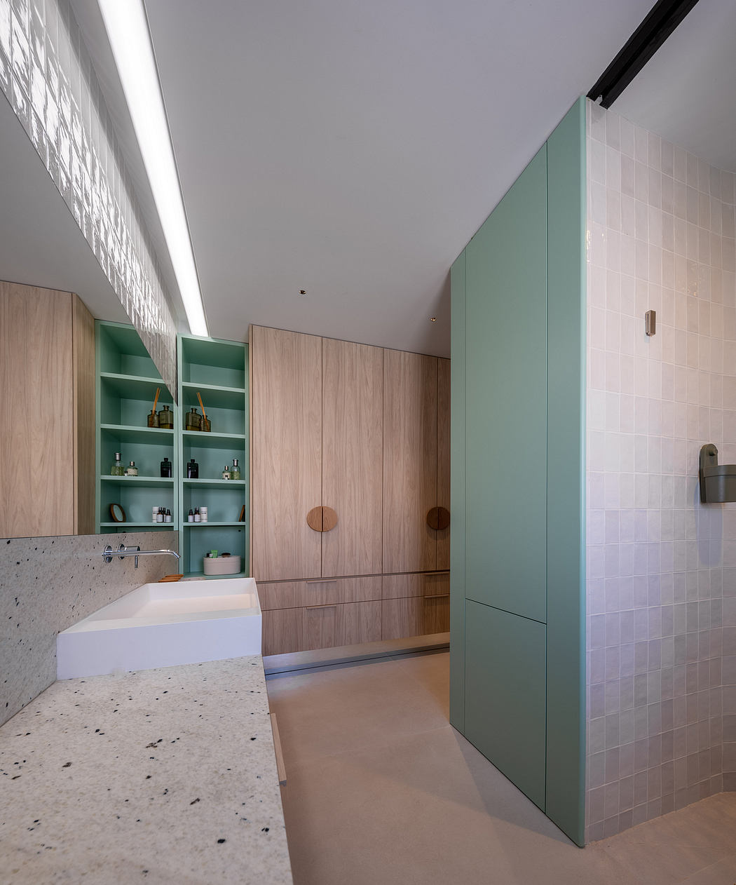 Sleek, modern bathroom with mint green cabinetry, white tiles, and minimalist design.
