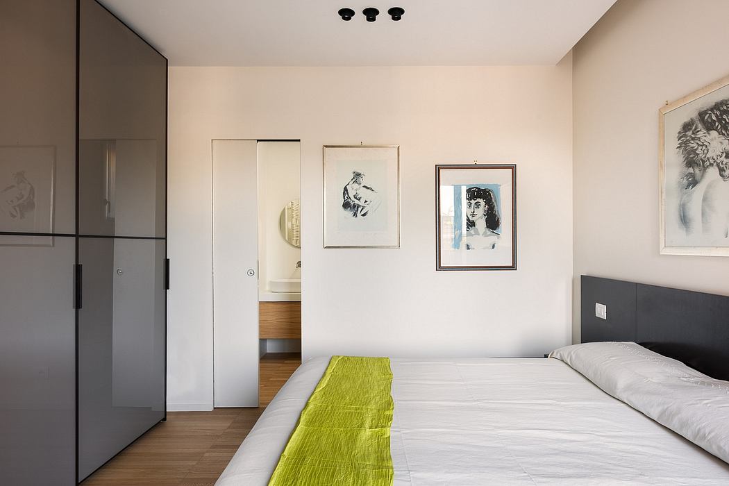 Well-designed bedroom with sleek black furniture, framed artwork, and hints of natural wood accents.