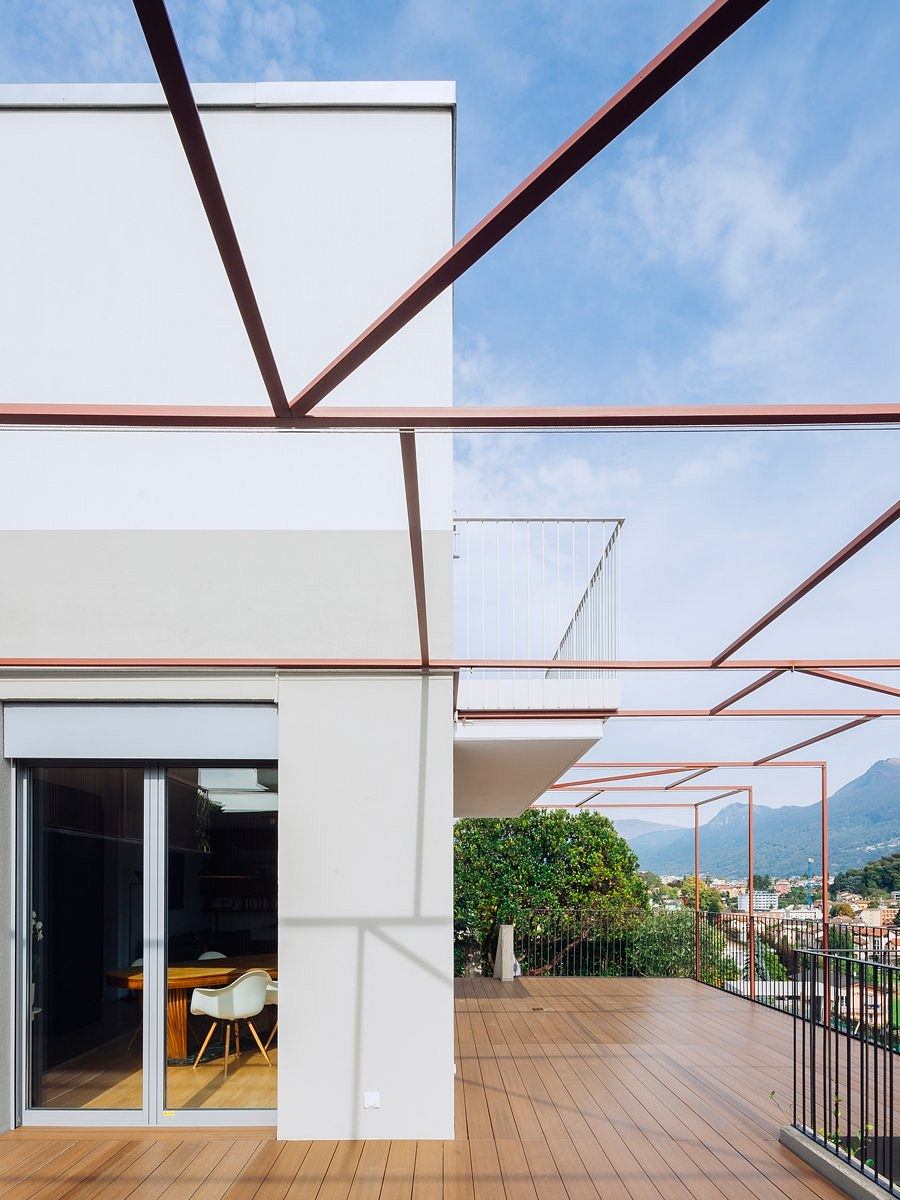 Modern architectural design with clean lines, large windows, and a spacious outdoor deck with a view.