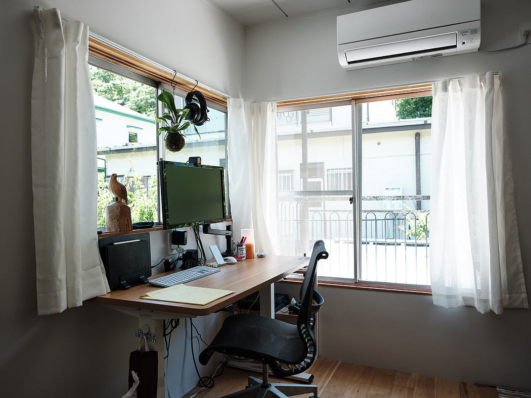 Cozy home office with large window, air conditioning unit, and nature decor.
