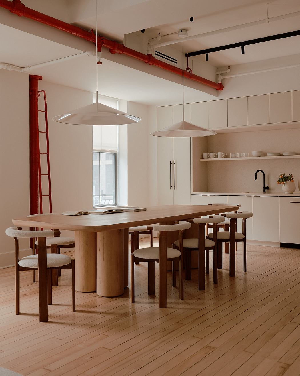 A sleek, modern kitchen and dining space with wooden details and pendant lighting.