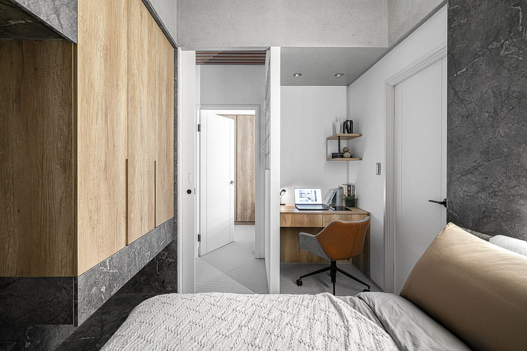 A modern, minimalist bedroom with wooden wall paneling, a desk space, and recessed lighting.
