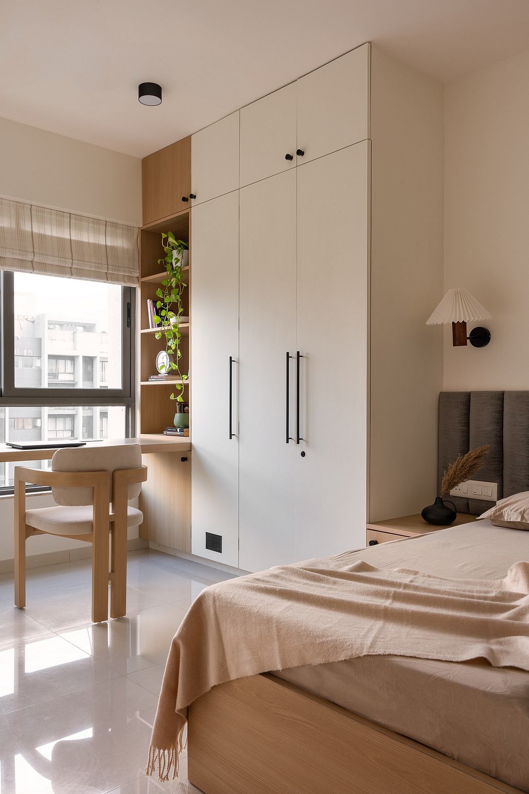 Cozy bedroom with minimalist white wardrobe, wood accents, and a comfortable bed.