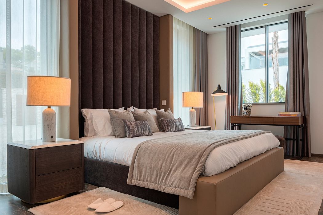 Elegant contemporary bedroom with plush headboard, bedding, and lighting fixtures.