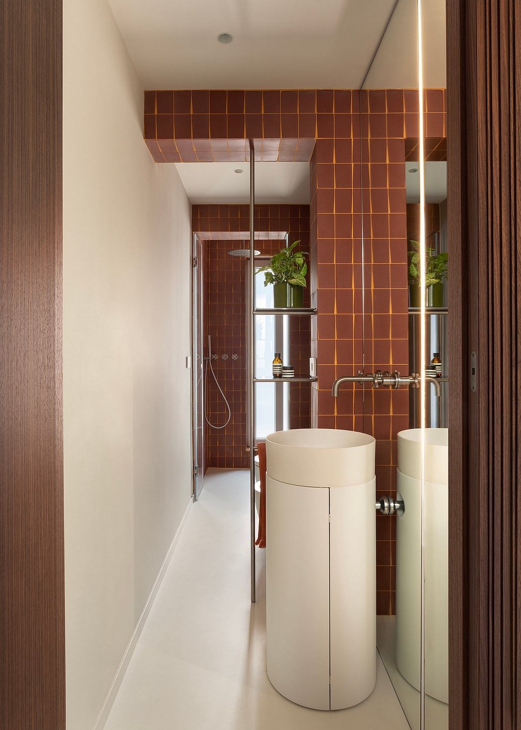 Warm-hued tiled walls, modern vessel sinks, and sleek plumbing elements create a stylish bathroom.