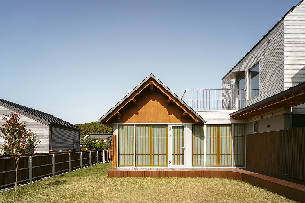 A modern Japanese-style house with a wooden facade, sliding glass doors, and a small yard.