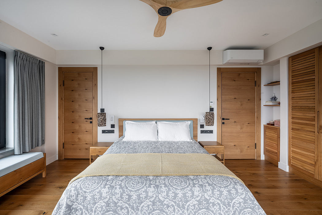 A cozy bedroom with a wooden bed frame, pendant lights, and a sleek ceiling fan.