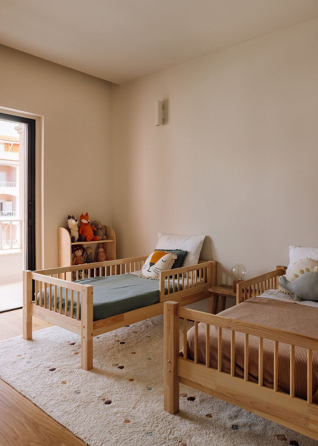 A cozy children's bedroom with wooden crib and shelving, plush toys, and a serene atmosphere.