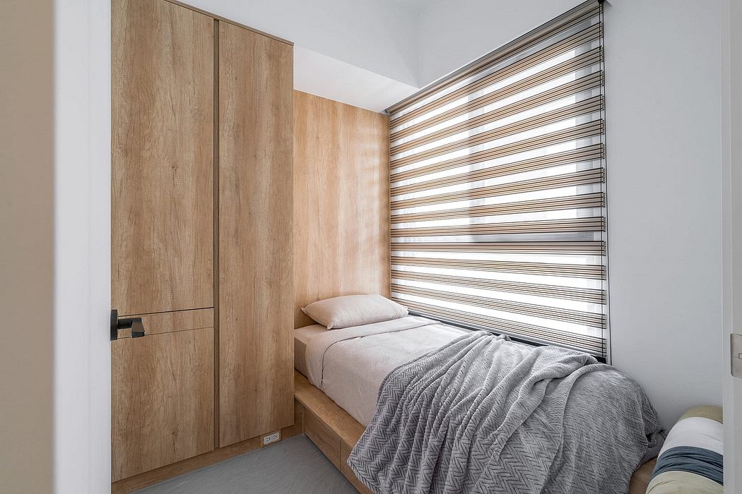 Minimalist bedroom with wood-paneled walls, curtain blinds, and a single bed with a gray blanket.