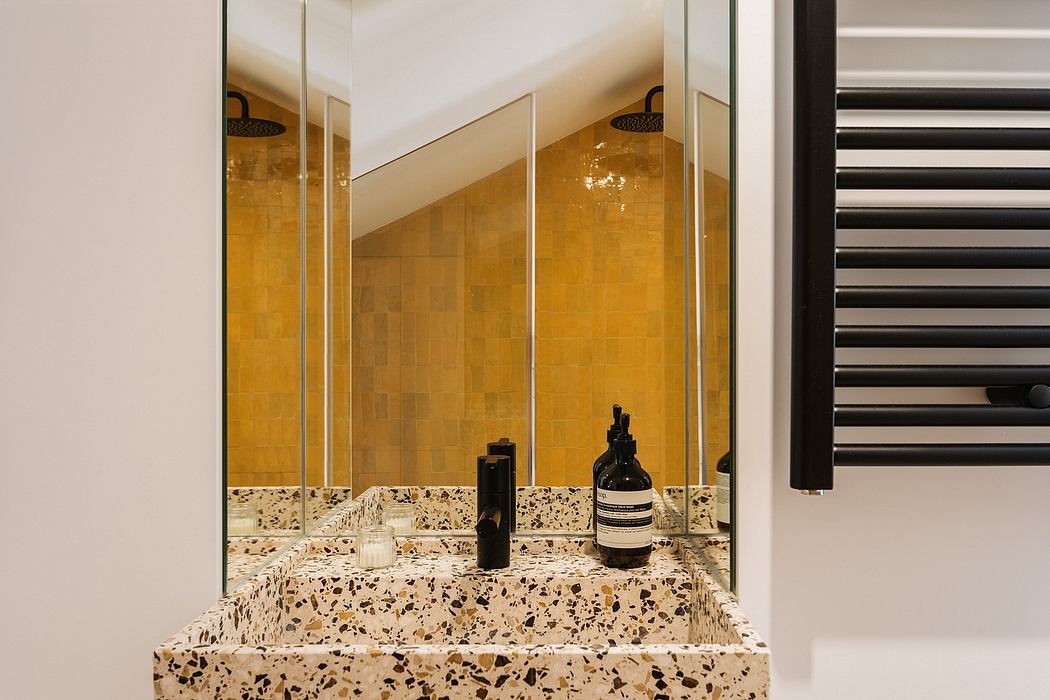 Luxurious bathroom with sleek glass panels, warm-toned tile walls, and terrazzo countertop.