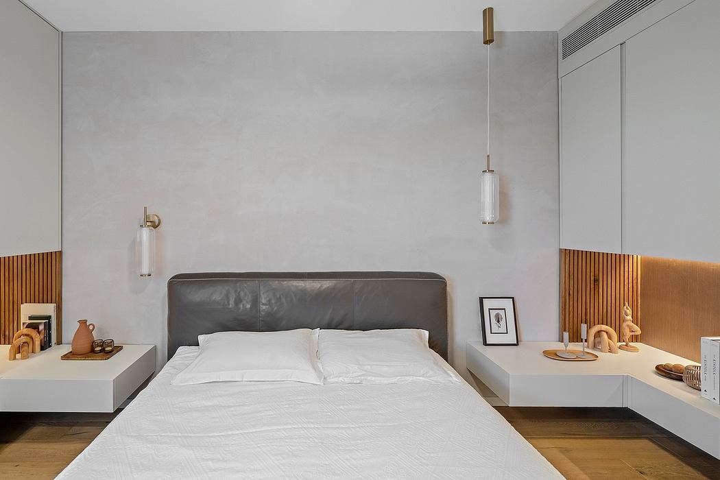 Sleek, modern bedroom with minimalist decor, leather headboard, and pendant lighting.
